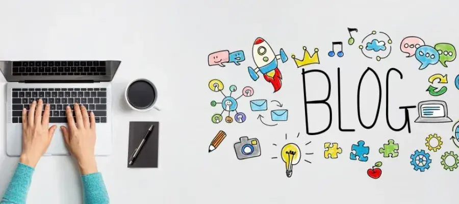 Person writing on laptop, with a blog illustration on the table